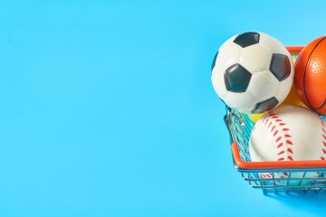 Different,Balls,In,Metal,Market,Basket,On,Blue,Background.,Purchasing